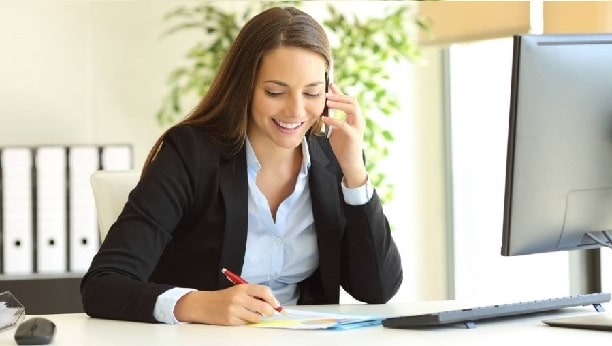 Vrouw die aan het bellen is achter een bureau