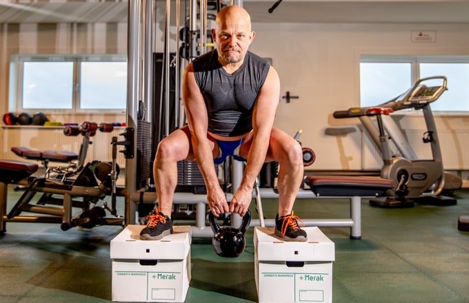 Sporter staat op twee Merak archiedozen om aan te tonen hoe sterk ze zijn