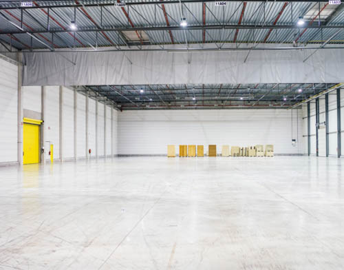 Spacious, modern storage space with yellow doors and a pristine floor.