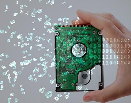 A hand holding a hard disk where data digits float around