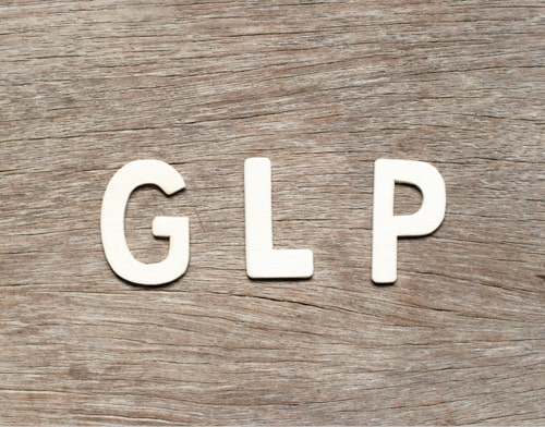 Witte letters die GLP spellen op een houten achtergrond