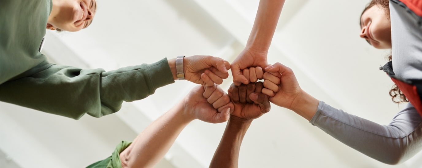 Four people give each other a fist bump