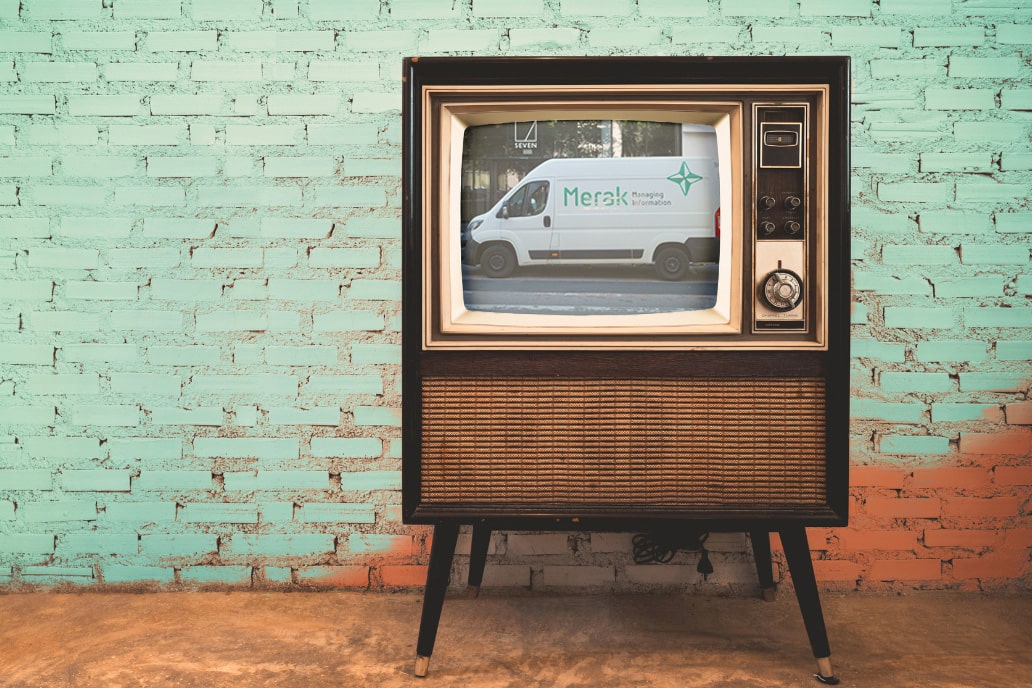 Green leaves with an illustration of an eco-friendly world and Merak archive boxes in the background